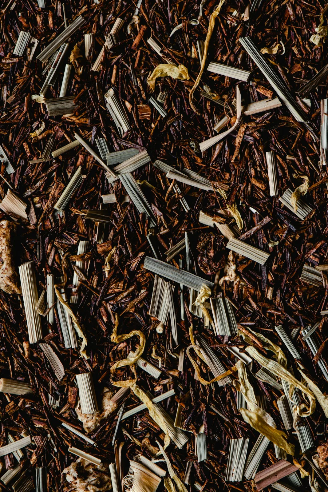 Loose rooibos tea leaves in a detailed reddish-brown close-up.